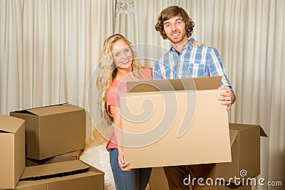 Happy couple carrying a moving box Stock Photo