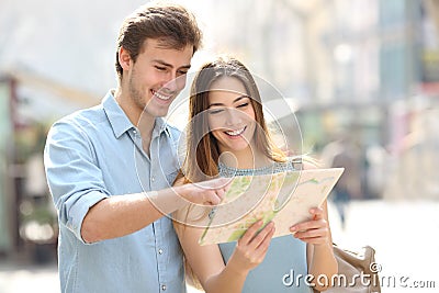 Happy couple checking paper map on vacation Stock Photo