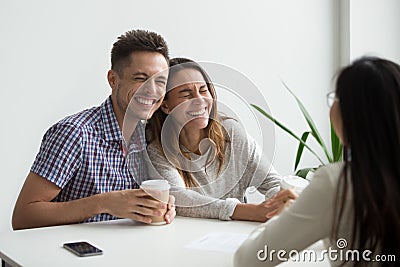 Happy couple clients laughing planning to sign contract at meeti Stock Photo