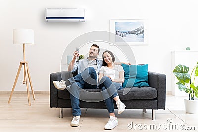 Happy couple cool down using air conditioning at home Stock Photo