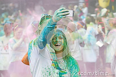 Happy couple covered with blue and green color powder taking selfie Editorial Stock Photo