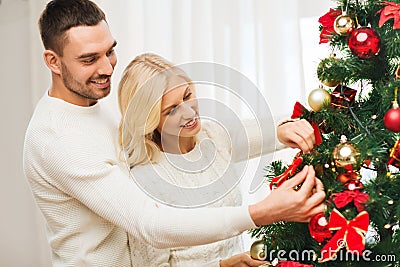 Happy couple decorating christmas tree at home Stock Photo