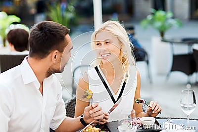 Happy couple eating dinner at restaurant terrace Stock Photo