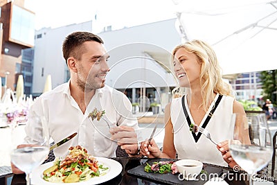 Happy couple eating dinner at restaurant terrace Stock Photo