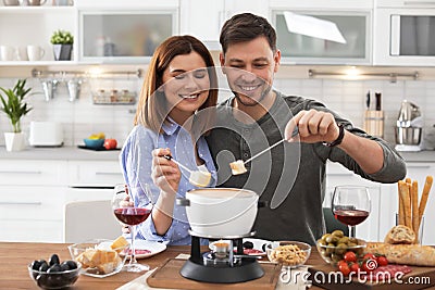 Happy couple enjoying fondue dinner Stock Photo