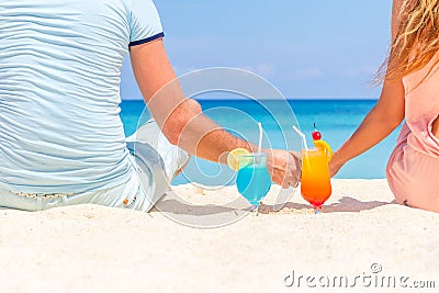 Happy couple enjoying tropical cocktails on sand beach Stock Photo