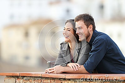 Happy couple enjoying views in a terrace on vacation Stock Photo