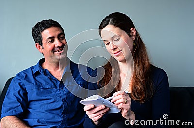 Happy couple filling shopping list Stock Photo