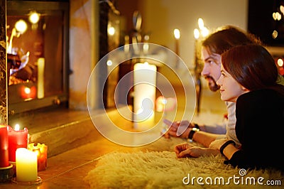 Happy couple by a fireplace on Christmas Stock Photo