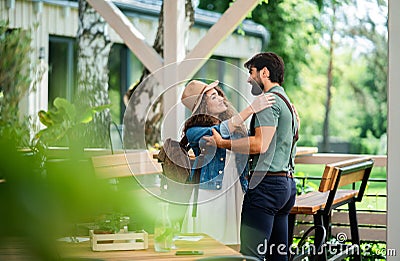 Happy couple greeting outdoors on terrace restaurant, end of lockdown. Stock Photo