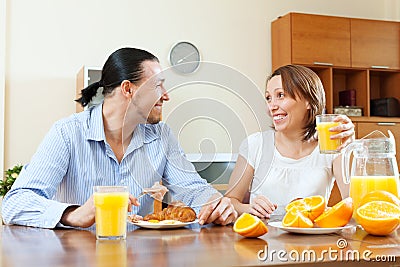 Happy couple having breakfast with oranges juice Stock Photo