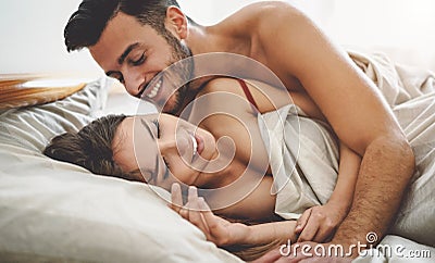 Happy couple having fun on bed under blanket Stock Photo