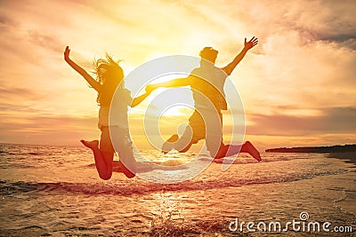happy couple jumping on beach Stock Photo