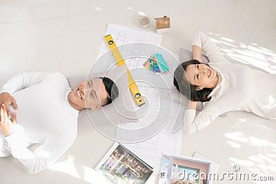 Happy couple looking at new house blueprints at home Stock Photo