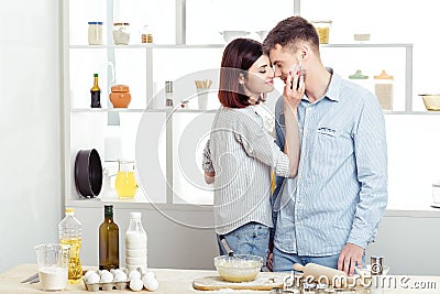 Happy Couple in love cooking dough and kissing in kitchen Stock Photo