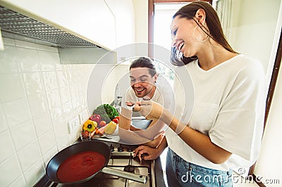 Happy couple in love having fun cooking togheter at home. Stock Photo