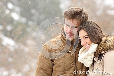 Happy couple in love looking away in winter Stock Photo