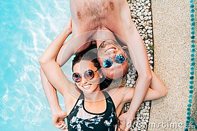 Happy couple in love lying on the pool edge Stock Photo