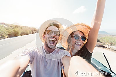 Happy couple taking a selfie in a convertible car. Stock Photo
