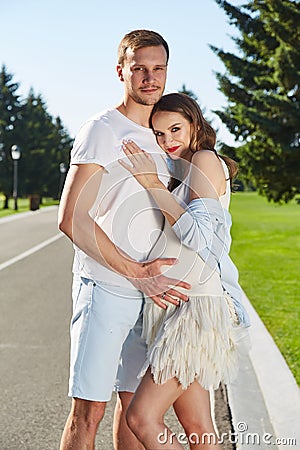 Happy couple in love waiting for child pregnancy hug walk in the summer park green trees nature husband and wife baby boy young Stock Photo