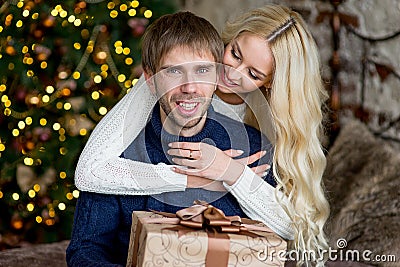 Happy couple of lovers in pullovers give each other gifts Stock Photo