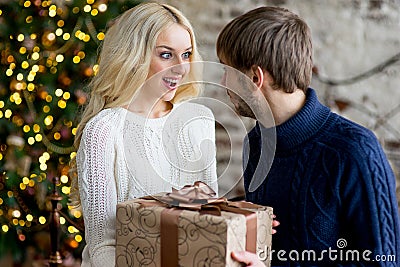 Happy couple of lovers in pullovers give each other gifts Stock Photo