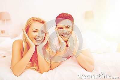 Happy couple lying in bed at home Stock Photo