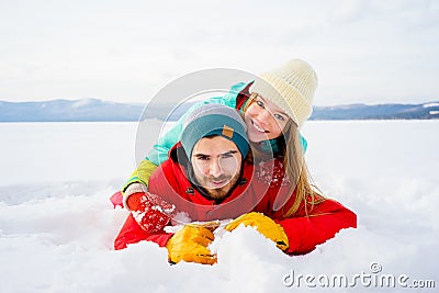 Happy couple lying in snow Stock Photo