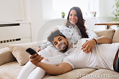 Happy couple lying on sofa together and relaxing at home Stock Photo