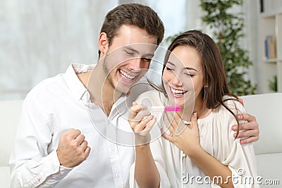 Happy couple making positive pregnancy test Stock Photo