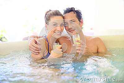 Happy couple making a toast with champagne in jacuzzi Stock Photo