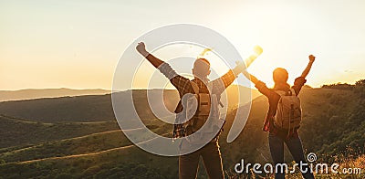Happy couple man and woman tourist at top of mountain at sunset Stock Photo