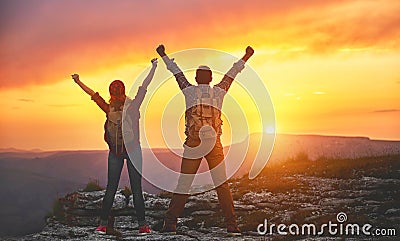 Happy couple man and woman tourist at top of mountain at sunset Stock Photo