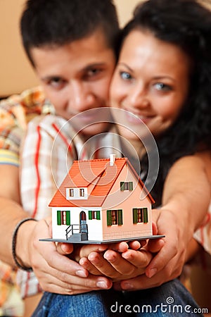 Happy couple with miniature house Stock Photo