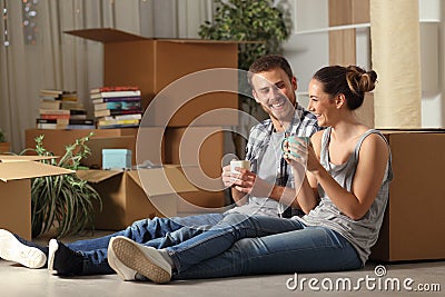 Happy couple moving home resting and talking Stock Photo