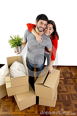 Happy couple moving together in a new house unpacking cardboard boxes Stock Photo