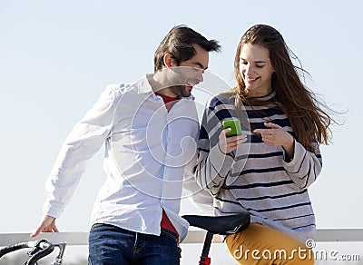 SAYKA happy couple outside looking text message cell phone close up portrait standing 48495059