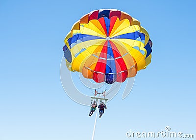 Happy couple Parasailing in Dominicana beach in summer. Couple under parachute hanging mid air. Having fun. Tropical Paradise. Pos Stock Photo