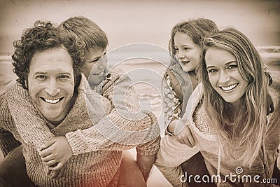 Happy couple piggybacking kids at beach Stock Photo