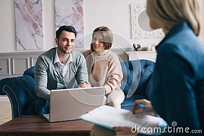 Happy couple planning their future while consulting with insurance agent in their home. Stock Photo