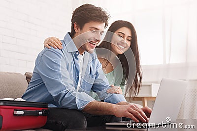 Happy couple planning travel, booking tickets online on laptop Stock Photo