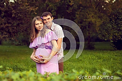 Happy couple posing in the Park in anticipation of the child. Ma Stock Photo