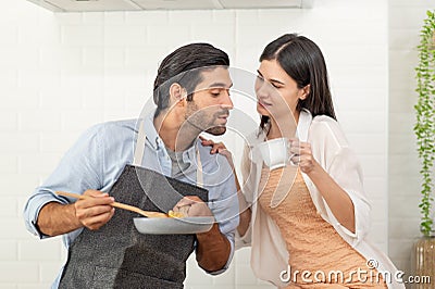 Happy couple preparing food at home, young couple cutting vegetables together at kitchen counter Stock Photo