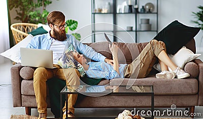 Happy couple relaxing at home with laptop and tablet Stock Photo