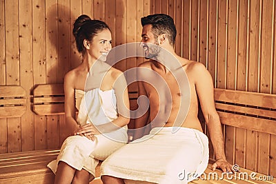 Happy couple relaxing inside sauna spa resort hotel - Romantic young lovers having relaxing day in luxury steam bath salon Stock Photo