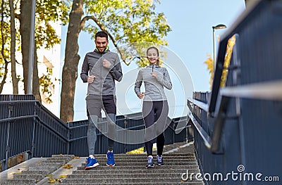 Happy couple running downstairs in city Stock Photo