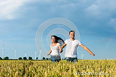 Happy couple running over grainfield Stock Photo