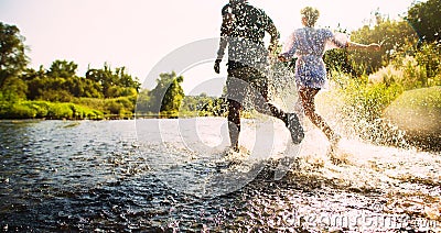 Happy couple running in shallow water Stock Photo