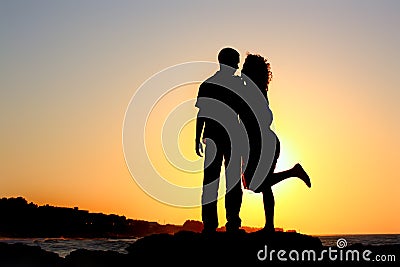 Happy couple by the sea silhouette Stock Photo