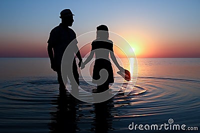 A Happy couple by the sea at sunset on travel silhouette in nature Stock Photo